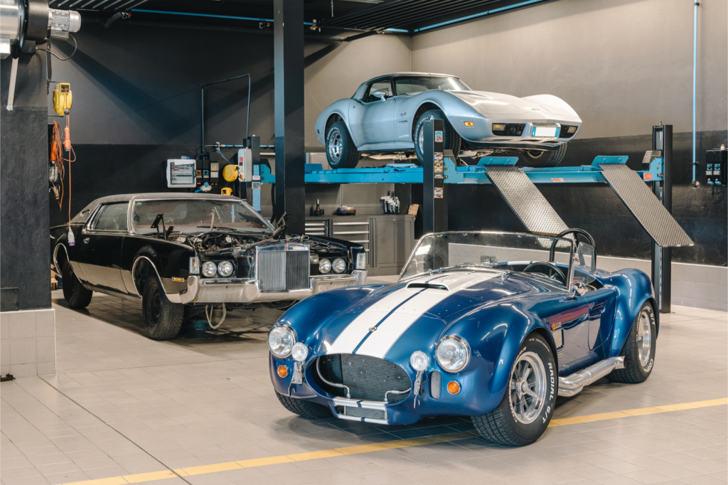Mobili da officina di 3D Beta, tra cui armadi e banchi da lavoro moderni in un grande garage per auto.