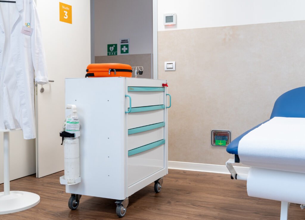 Arredi da laboratorio in una stanza della clinica della Casa della Salute con carrello medico e letto con Beta 3D