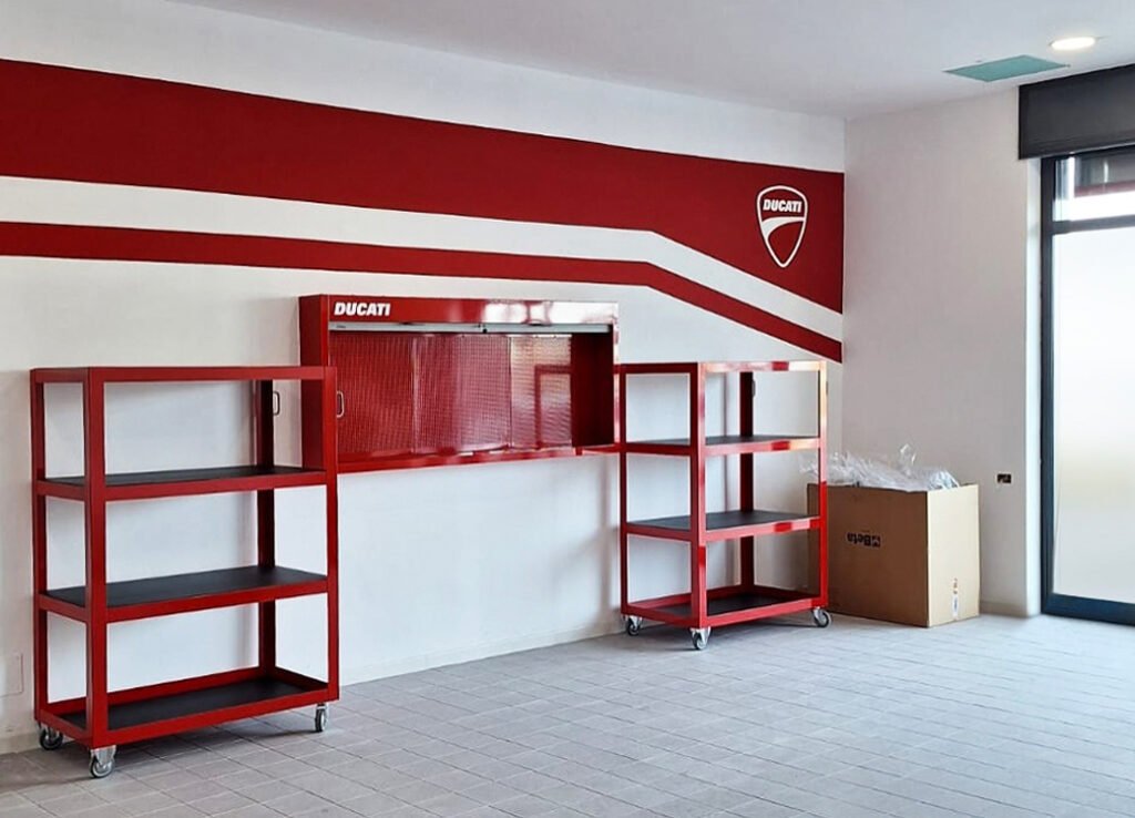 Mobili e armadi da officina presso l'Officina Moto Centro Moto Colucci Matera con logo a parete