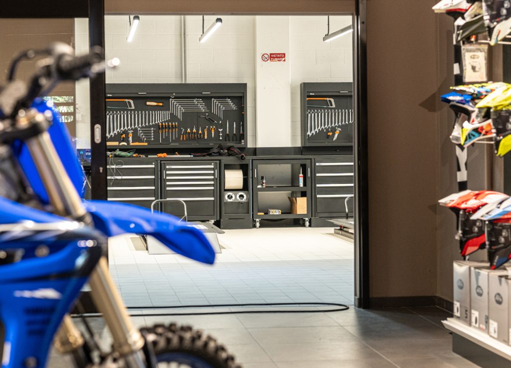 Mobili da officina con armadietti Beta 3D e cassette degli attrezzi disposti ordinatamente su scaffali espositivi in un'officina