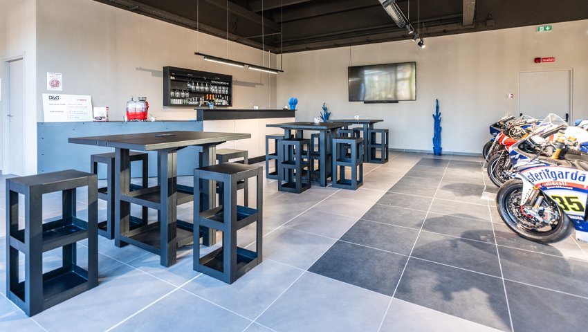 Mobili da officina armadi da officina su misura e arredi 3D Beta in un salone con bar e TV a parete