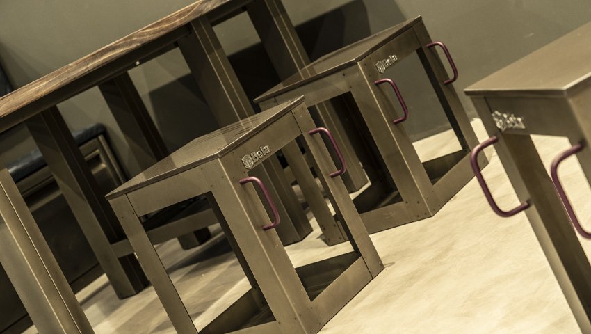 Workshop furniture with metal stools featuring side handles and a wooden table by 3D Beta for workshops