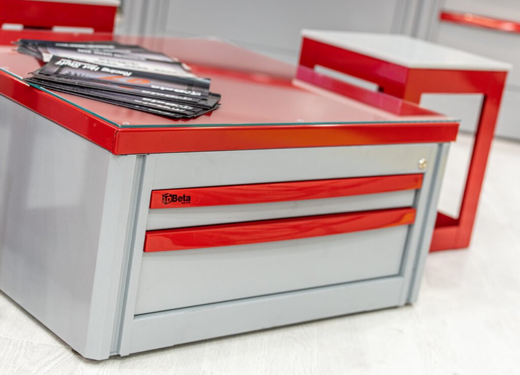 Workshop furniture from 3D Beta at EICMA 2022 with storage drawers and brochures on a light floor