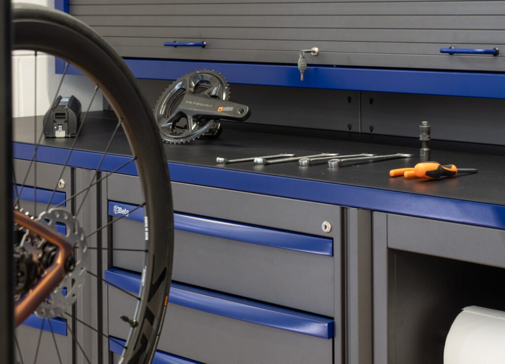 Arredamento dell'officina Gli strumenti e i pezzi di Beta 3D sono ordinatamente organizzati su un banco da lavoro in un'officina per biciclette.