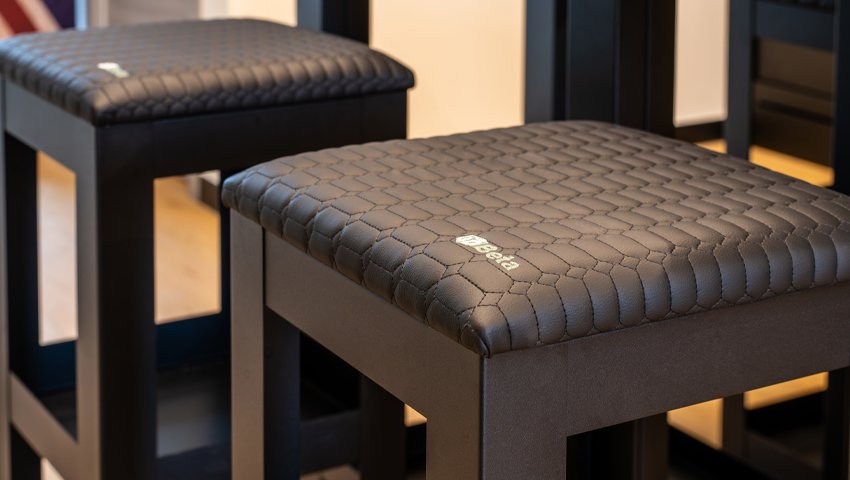 Mobili da officina con sgabelli da bar texturizzati e sedute geometriche presso Officina Moto Triumph Brescia