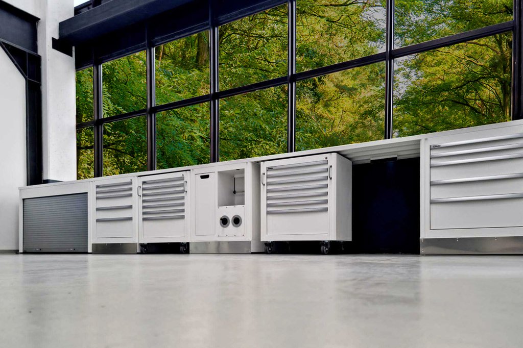 Mobili da officina armadi da 3D Beta mostrati sotto grandi finestre con vista sulla foresta