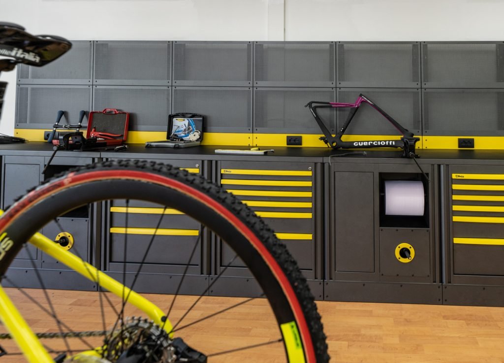 Mobili da officina con armadietti e strumenti a parete organizzati in un'officina professionale per moto Beta 3D