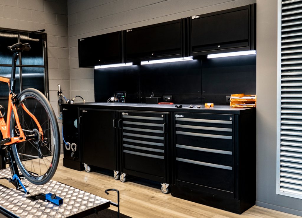 Mobili per officina e soluzioni di stoccaggio di 3D Beta in una moderna officina per biciclette con stand di riparazione nelle vicinanze