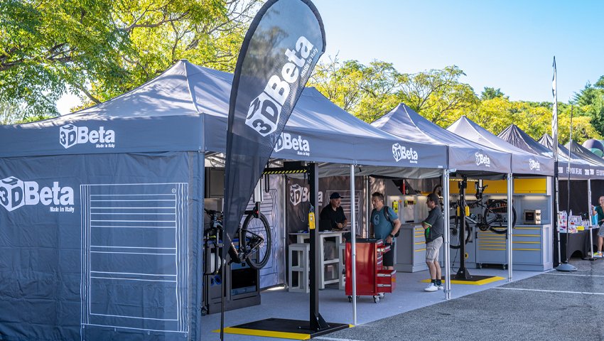 Mobili da officina di 3D Beta esposti all'Italian Bike Festival 2025 con gli stand dell'evento e la folla