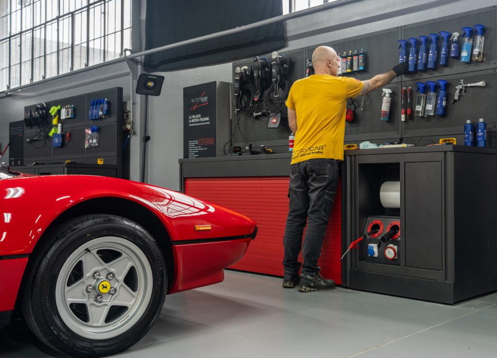 Arredi e magazzini dell'officina di 3D Beta visibili mentre la persona sceglie gli utensili presso l'Officina auto Esteticar