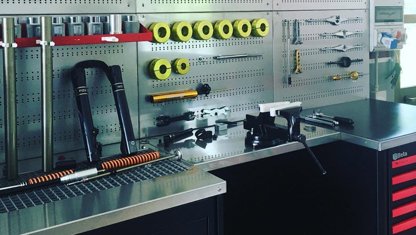 L'arredamento dell'officina mette in mostra strumenti Beta 3D organizzati su una bacheca sopra un banco da lavoro e una cassettiera per attrezzi