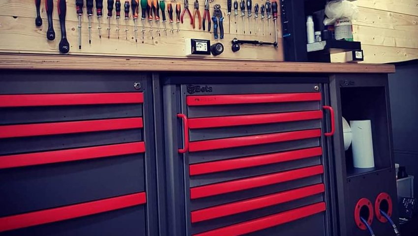 Arredamento per officina di 3D Beta con armadietti per attrezzi e utensili organizzati su una parete di legno in un negozio di professionisti